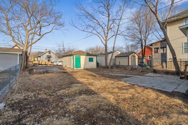 view of yard with a residential view, fence, an outbuilding, and a shed