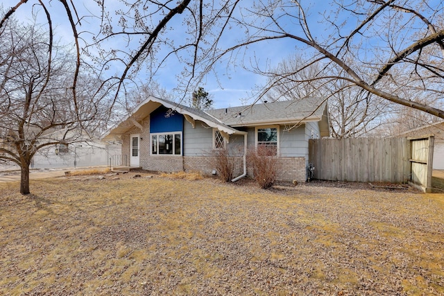 view of front of property with fence and brick siding