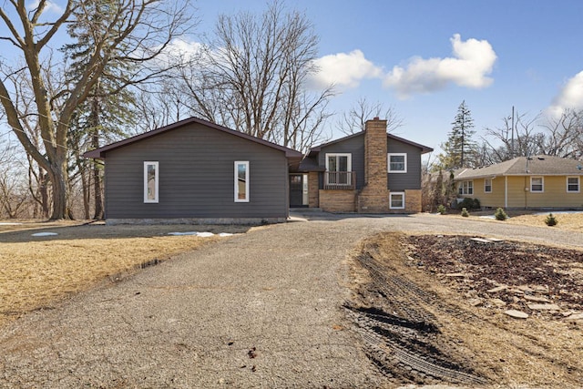 view of front facade with a chimney and dirt driveway