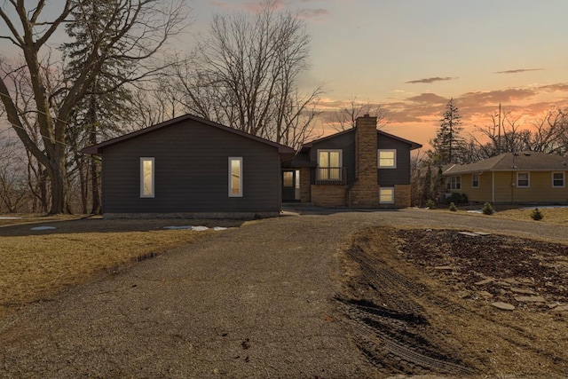 view of front of home featuring driveway and a chimney