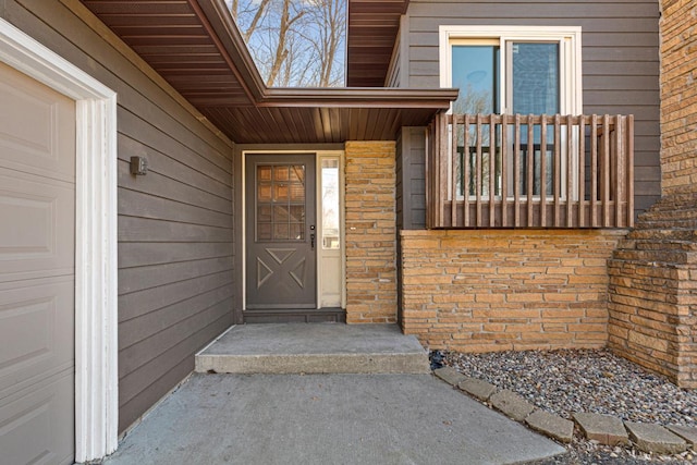 entrance to property featuring brick siding and an attached garage