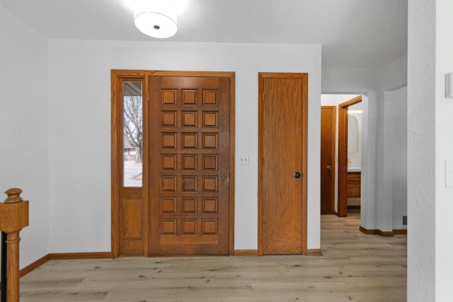 foyer featuring baseboards and light wood-style flooring