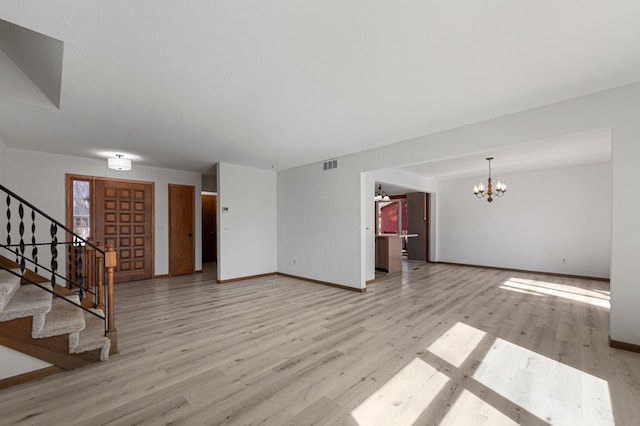 interior space featuring light wood finished floors, visible vents, stairs, and a notable chandelier