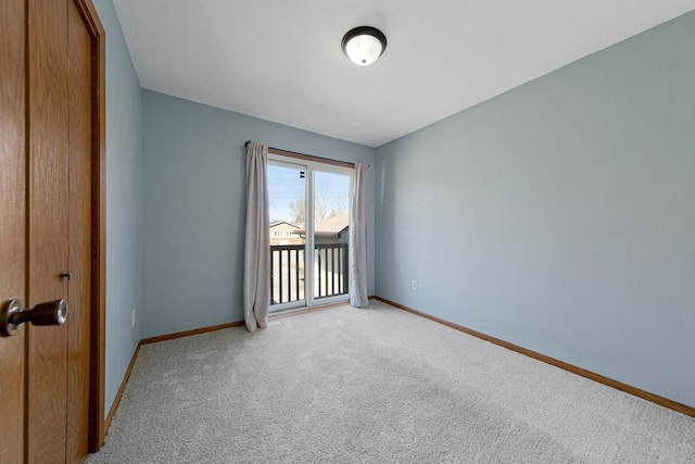 empty room featuring baseboards and light carpet