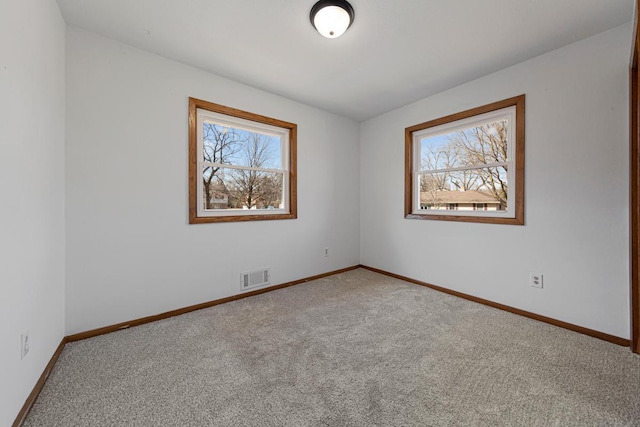 spare room featuring visible vents, carpet flooring, and baseboards