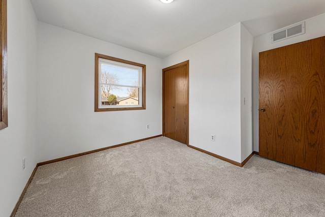 unfurnished bedroom with a closet, visible vents, baseboards, and carpet floors