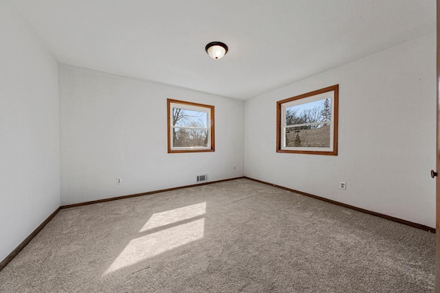 carpeted empty room with visible vents and baseboards