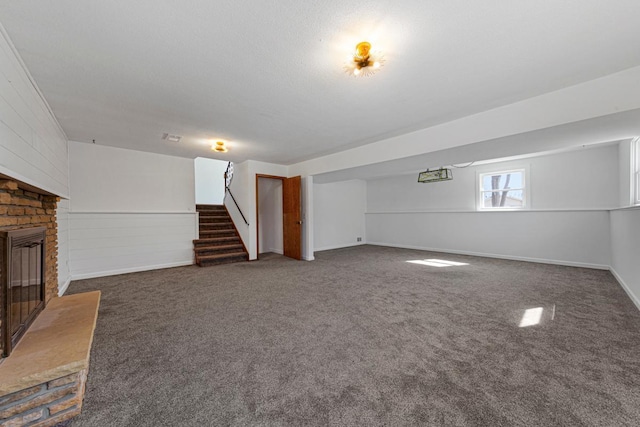 basement featuring stairway, carpet flooring, and a brick fireplace