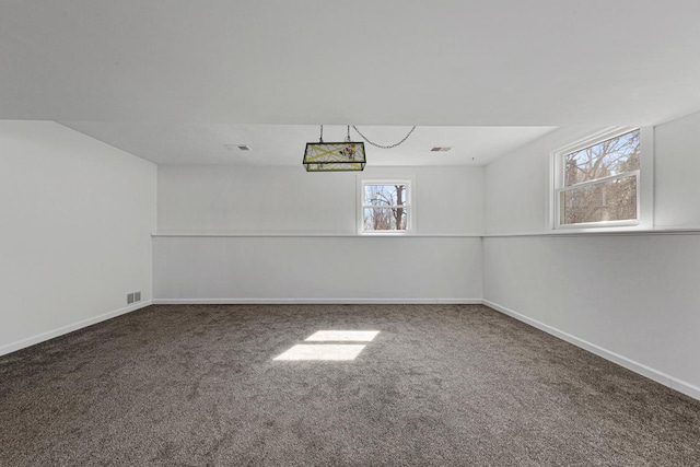 carpeted empty room featuring visible vents and baseboards