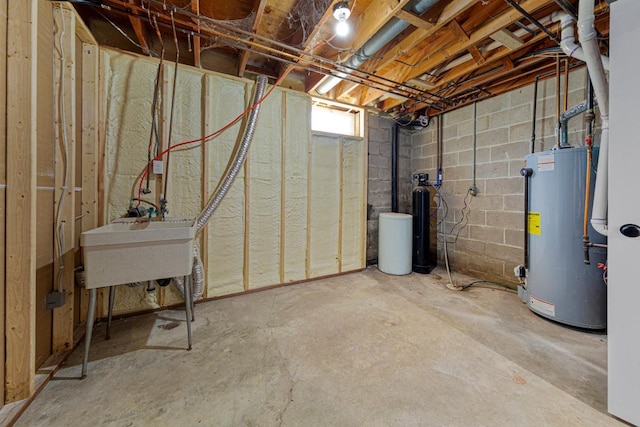 unfinished below grade area with water heater and a sink