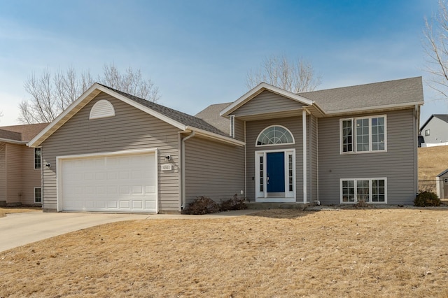 view of front of property with an attached garage, driveway, and roof with shingles