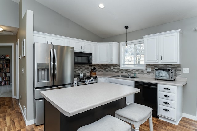 kitchen with a kitchen island, lofted ceiling, a sink, black appliances, and white cabinetry