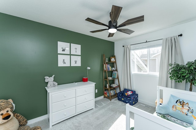 bedroom with light colored carpet, baseboards, and ceiling fan