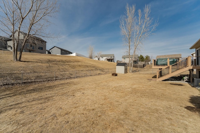 view of yard featuring an outbuilding, a storage shed, and fence