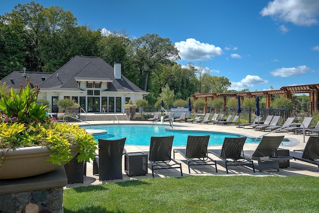 pool featuring a patio area, a yard, fence, and an outbuilding