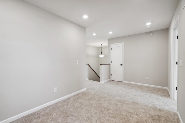 empty room with recessed lighting, light colored carpet, and baseboards