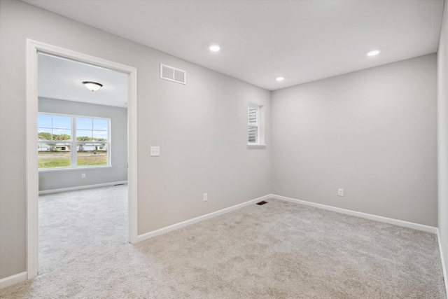 carpeted spare room with recessed lighting, visible vents, and baseboards