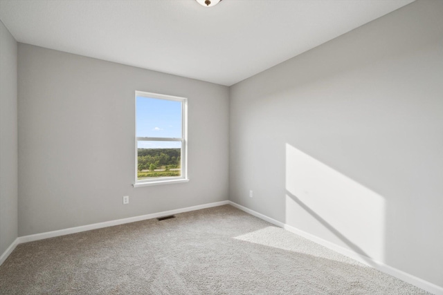 empty room with visible vents, carpet, and baseboards