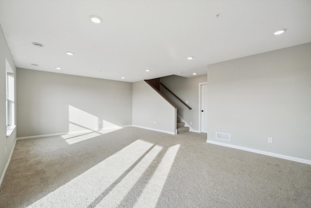 unfurnished room featuring baseboards, visible vents, recessed lighting, stairs, and light carpet