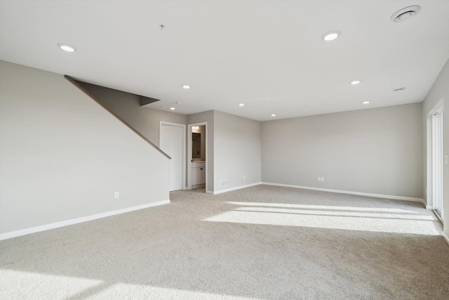 empty room featuring recessed lighting, baseboards, and light carpet