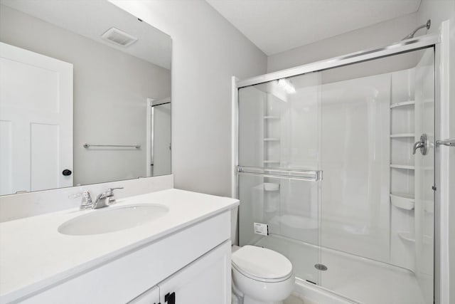 full bath with visible vents, a shower stall, toilet, and vanity