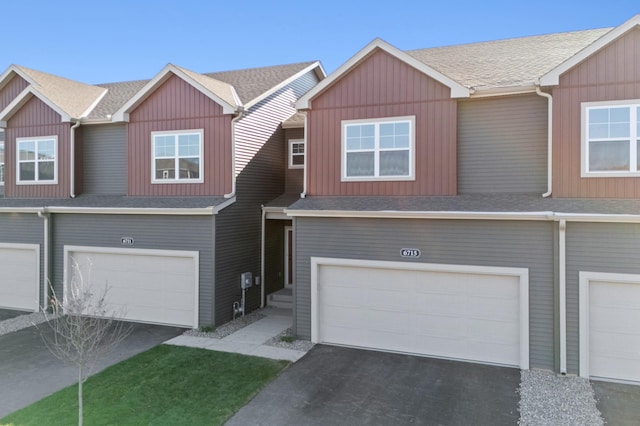 view of property featuring board and batten siding, a shingled roof, and a garage