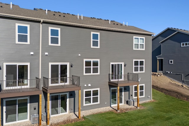 rear view of property featuring a yard and central AC