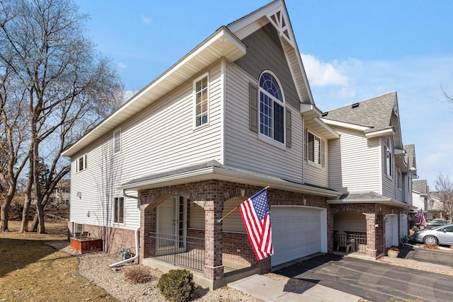 view of front of house featuring a garage, brick siding, and driveway