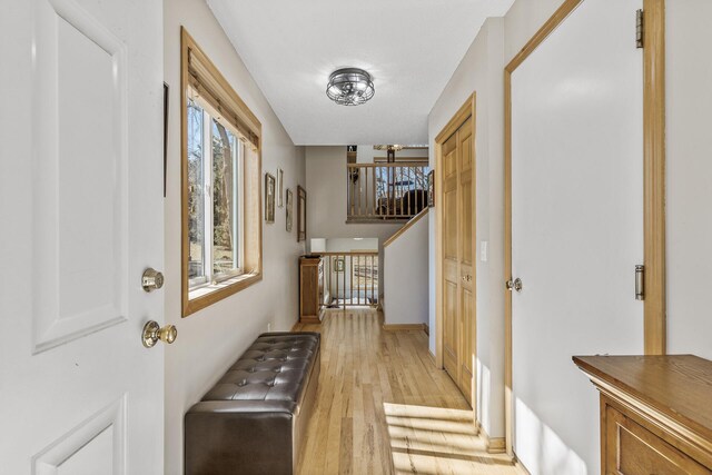 foyer entrance with stairs, plenty of natural light, light wood-style floors, and baseboards