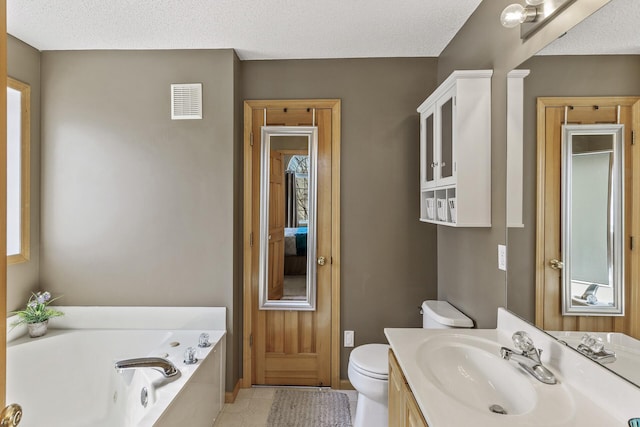 bathroom with visible vents, toilet, a whirlpool tub, tile patterned floors, and vanity