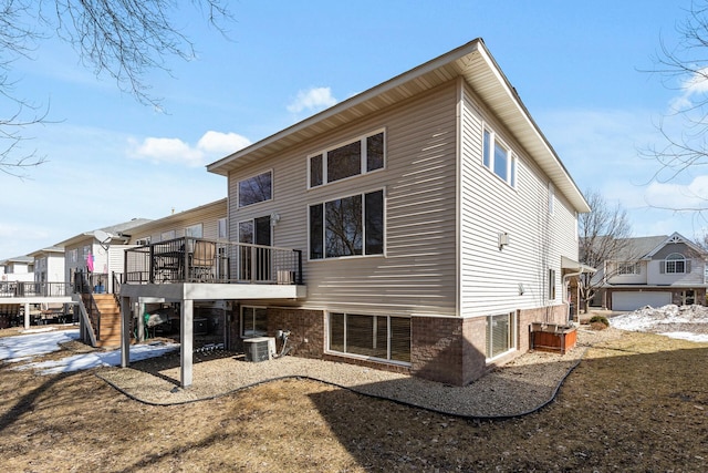 rear view of property with stairway, a wooden deck, central AC, and a residential view