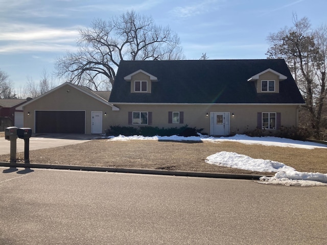 cape cod home with a garage and concrete driveway