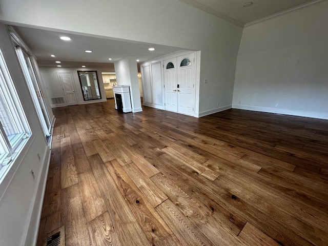 unfurnished living room featuring recessed lighting, baseboards, dark wood finished floors, and ornamental molding