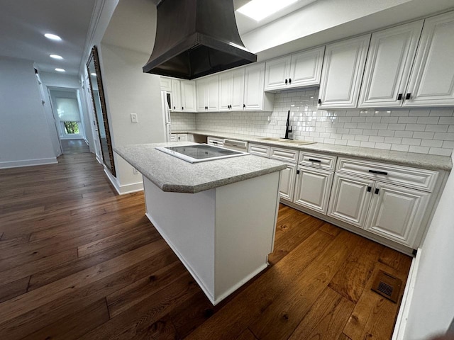 kitchen with a sink, dark wood-type flooring, stovetop, and premium range hood