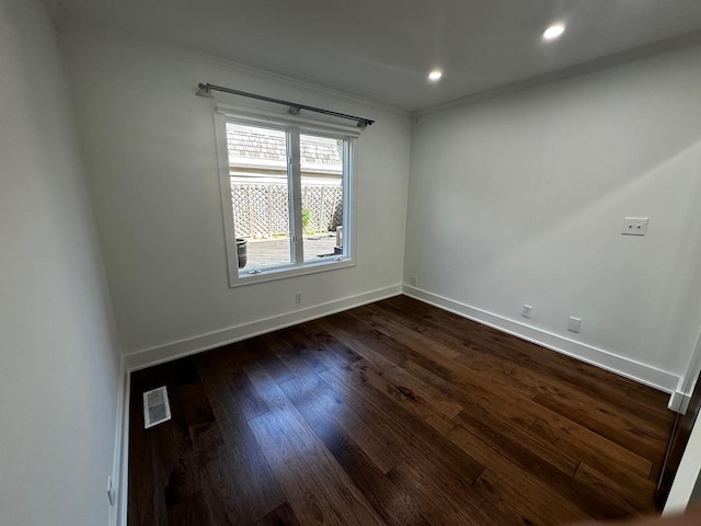 spare room with visible vents, recessed lighting, crown molding, baseboards, and dark wood-style flooring