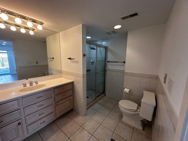 full bath with visible vents, toilet, tile walls, and tile patterned flooring