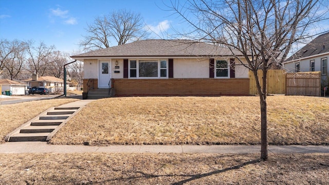 ranch-style home with brick siding, a shingled roof, and fence