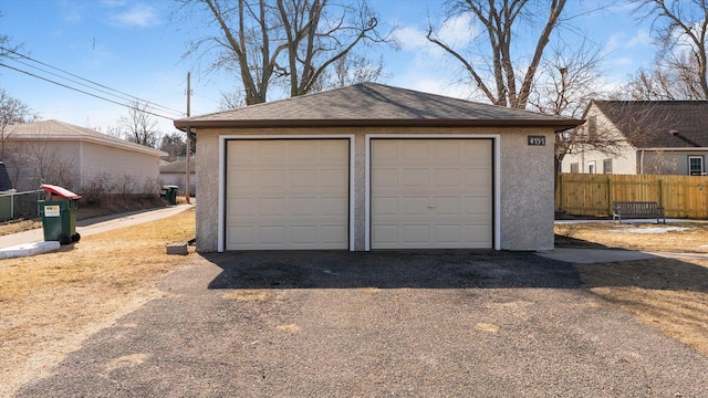 detached garage featuring fence