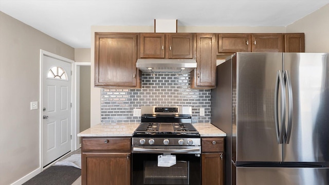 kitchen featuring ventilation hood, backsplash, brown cabinets, and appliances with stainless steel finishes