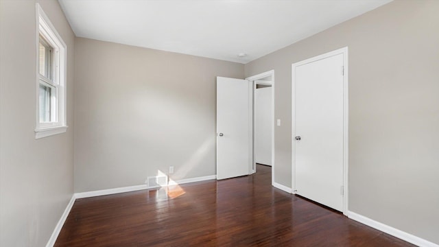 unfurnished bedroom with visible vents, baseboards, and wood finished floors