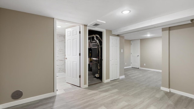 spare room with light wood-type flooring, visible vents, and baseboards