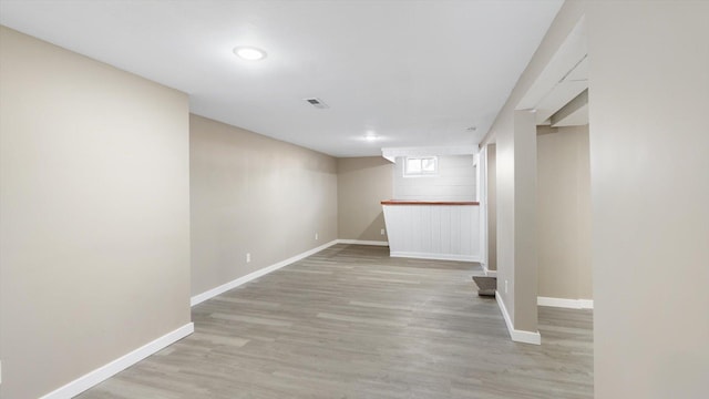 below grade area featuring visible vents, baseboards, and light wood-type flooring