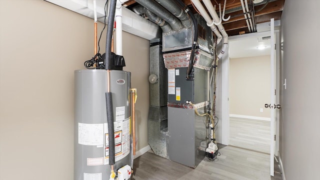 utility room with gas water heater and visible vents