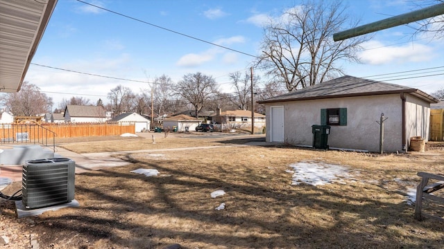 view of yard with an outbuilding, central AC unit, and fence