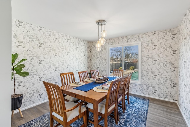 dining room with baseboards, wood finished floors, and wallpapered walls