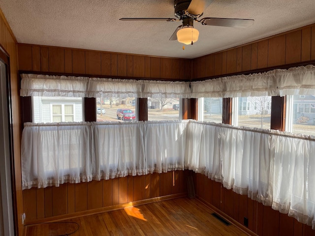 unfurnished sunroom with a ceiling fan and visible vents