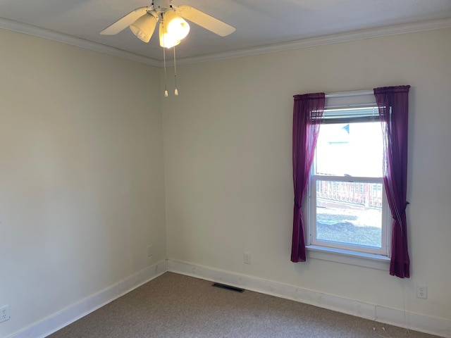 empty room featuring visible vents, carpet flooring, crown molding, and baseboards