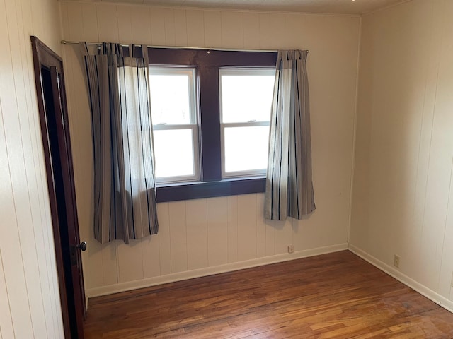 unfurnished room with wood finished floors and baseboards