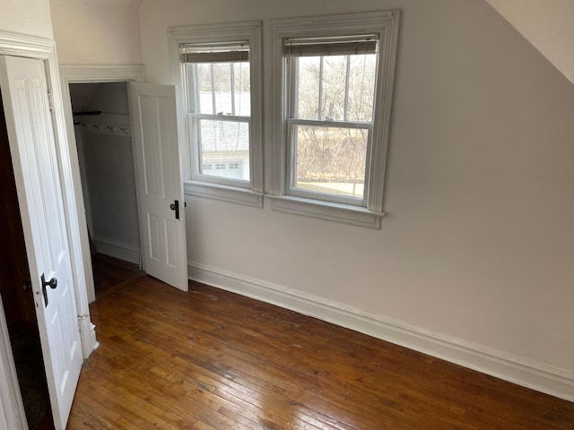 unfurnished bedroom with a closet, baseboards, and wood-type flooring