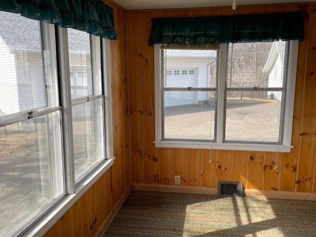 unfurnished dining area featuring wooden walls and visible vents